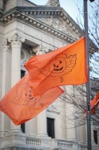 Photo fo an orange flag with a jack-o-lantern