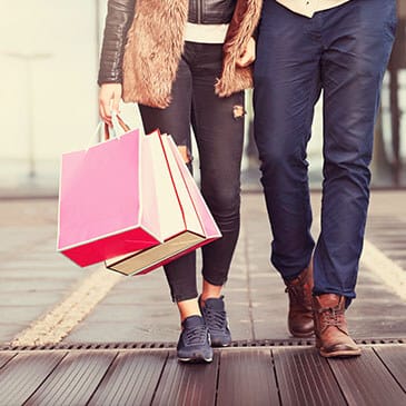 A couple holding hands with shopping bags 