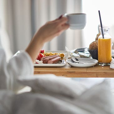 A woman enjoying breakfast in bed